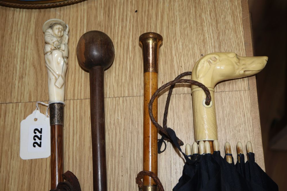 Three parasols, one with a carved ivory handle, and a hardwood walking cane